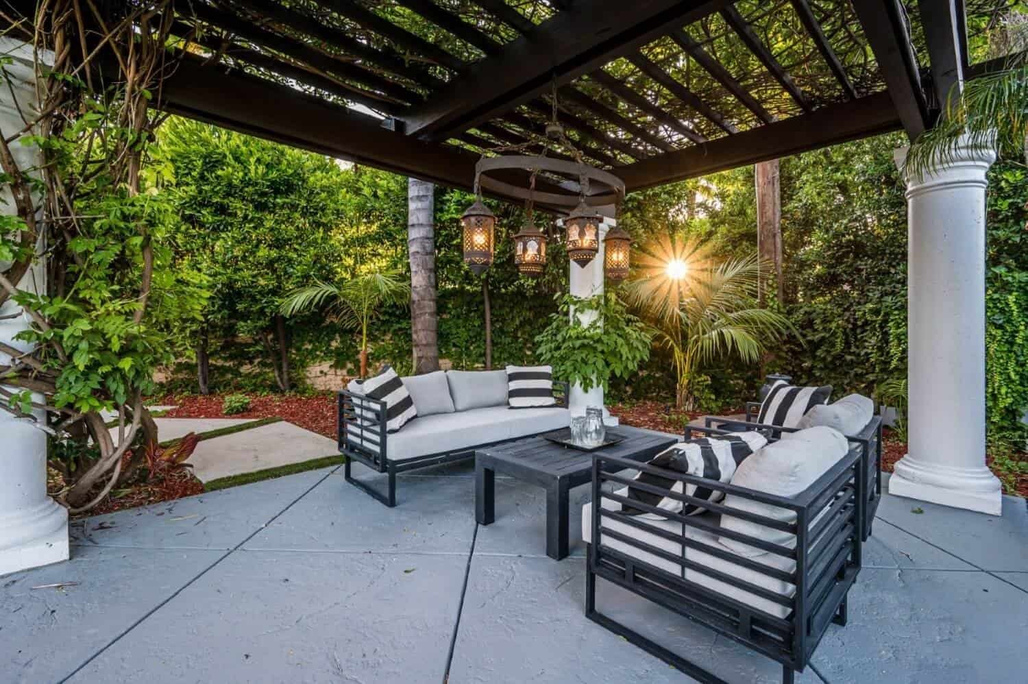 Elegant outdoor patio with seating and pergola at sunset.