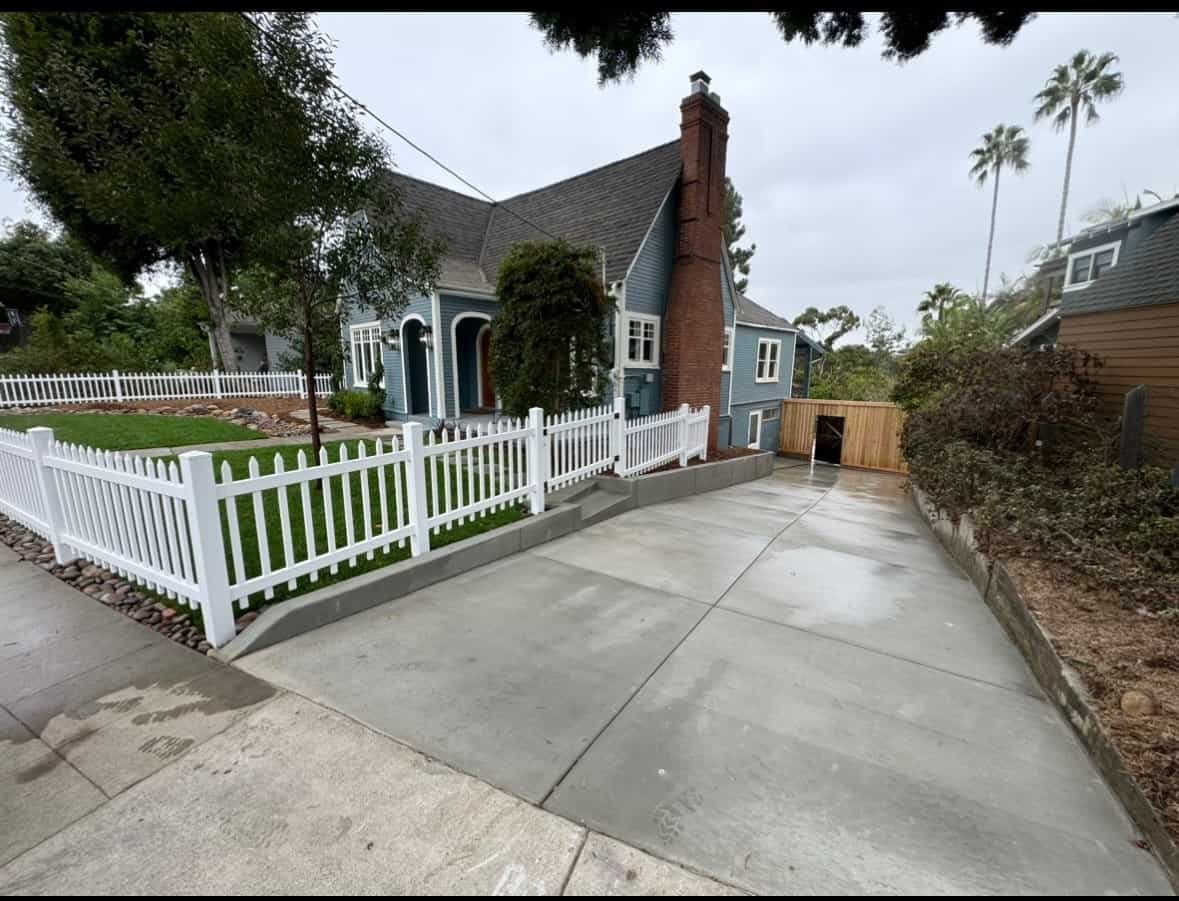 Residential driveway with clean concrete surface and landscaped yard.